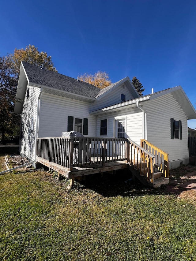 rear view of property with a lawn and a wooden deck