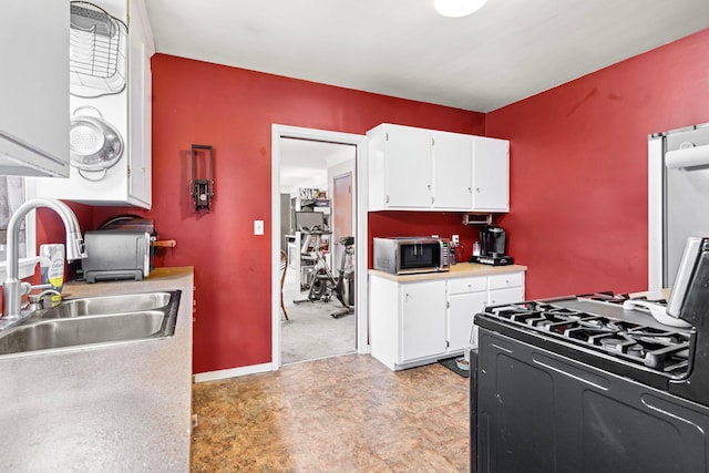 kitchen featuring white cabinetry, sink, and gas range oven