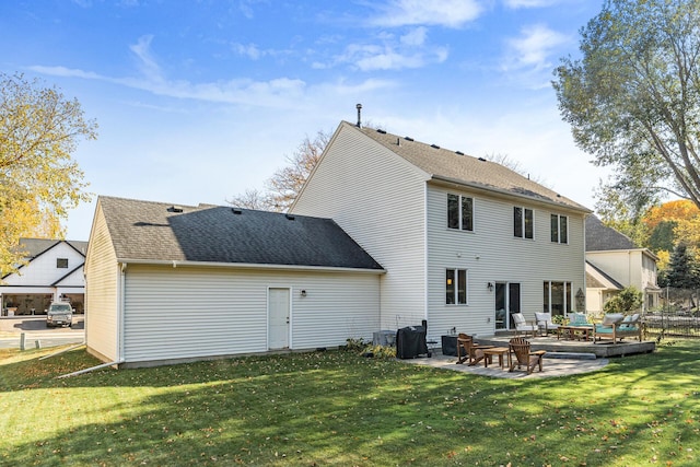 rear view of property featuring central air condition unit, a lawn, fence, a shingled roof, and a patio area