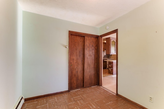 unfurnished bedroom with light parquet flooring and a baseboard radiator