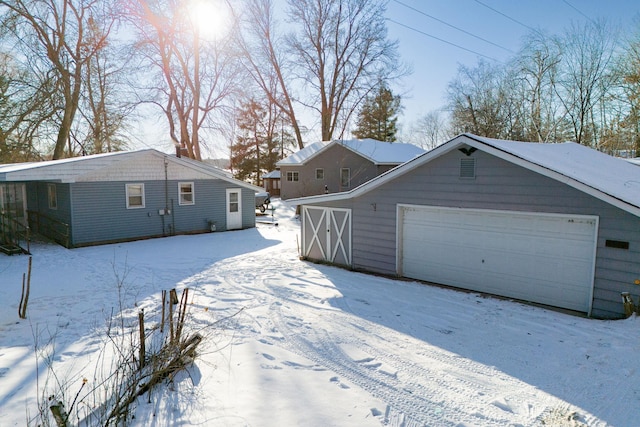 view of snowy exterior with a garage