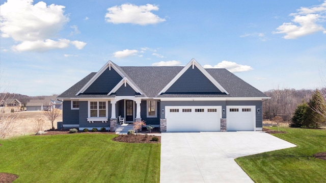 craftsman inspired home with a garage, roof with shingles, concrete driveway, and a front lawn