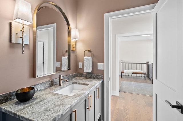bathroom with baseboards, wood finished floors, and vanity
