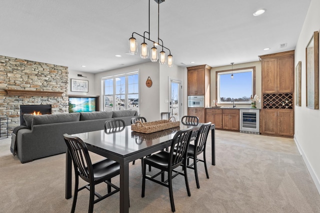 dining space with wine cooler, plenty of natural light, recessed lighting, and light colored carpet