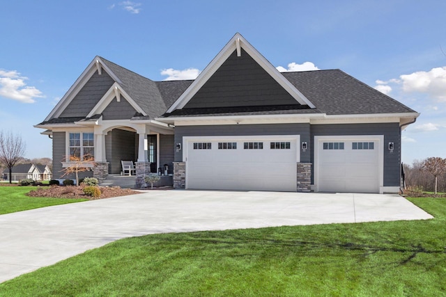craftsman inspired home featuring a garage, concrete driveway, a porch, and a front yard