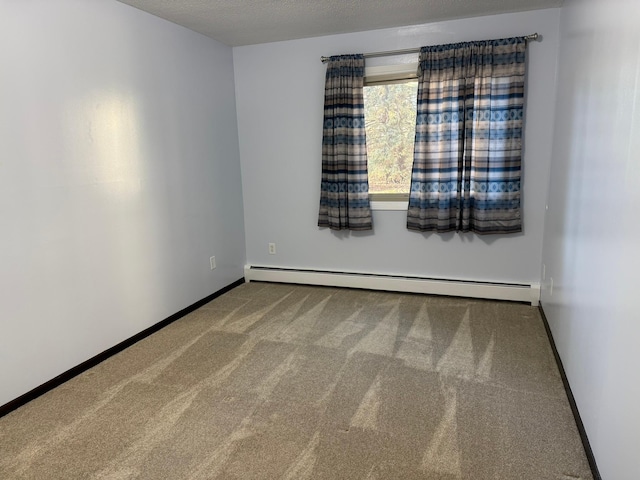 spare room featuring a baseboard heating unit, a textured ceiling, and carpet floors