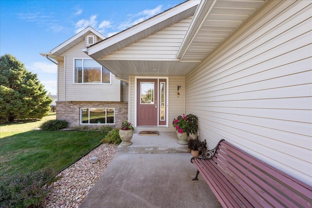 view of exterior entry with a yard