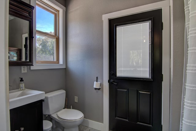 bathroom with curtained shower, vanity, and toilet