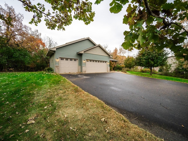 view of side of property with a garage and a lawn