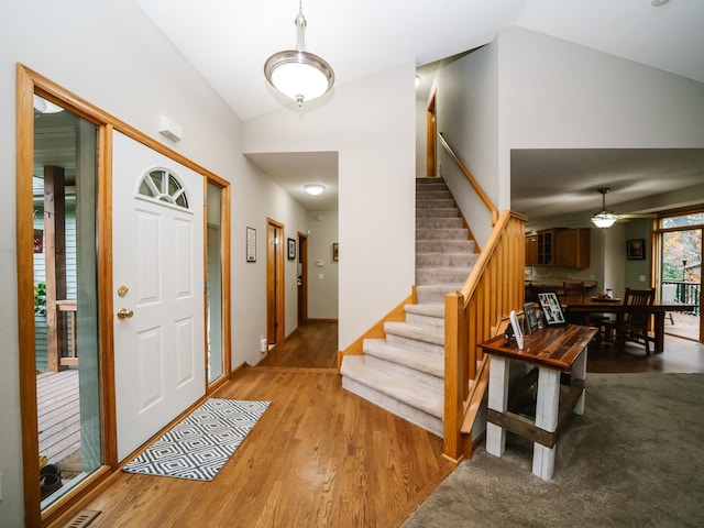 foyer featuring light hardwood / wood-style flooring, lofted ceiling, and ceiling fan