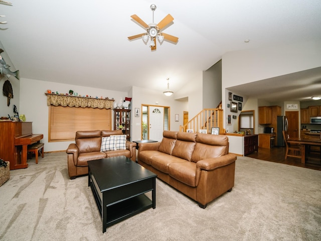 living room with ceiling fan, lofted ceiling, and light colored carpet