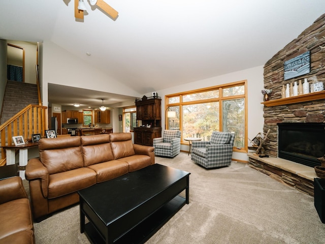 living room with high vaulted ceiling, a fireplace, light colored carpet, and ceiling fan