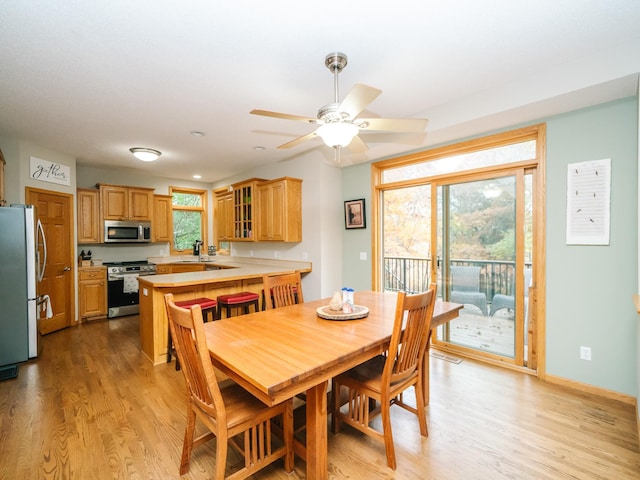 dining space featuring light hardwood / wood-style floors, sink, and ceiling fan