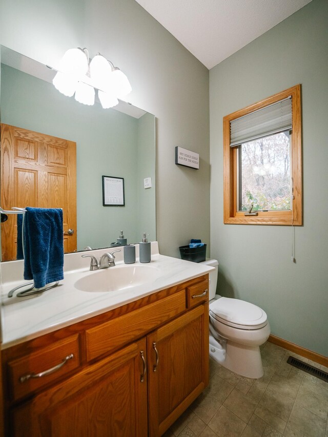 bathroom featuring toilet, vanity, and tile patterned flooring