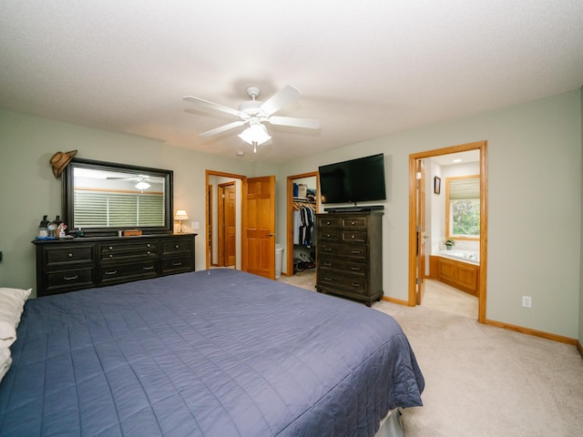 carpeted bedroom featuring connected bathroom, ceiling fan, a closet, and a spacious closet