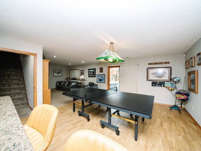 game room with light hardwood / wood-style flooring and a textured ceiling