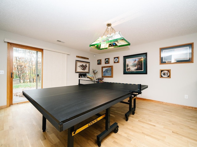 rec room with a textured ceiling and light wood-type flooring