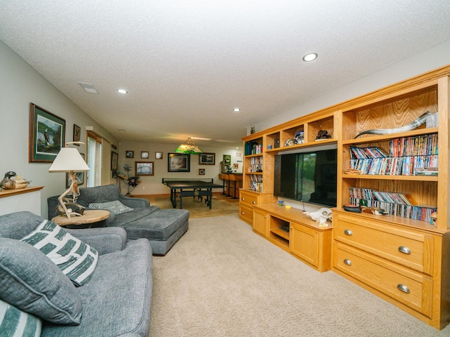 living room with a textured ceiling and light colored carpet