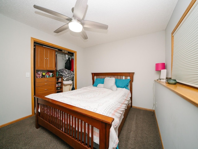 bedroom featuring dark colored carpet, a textured ceiling, a closet, and ceiling fan