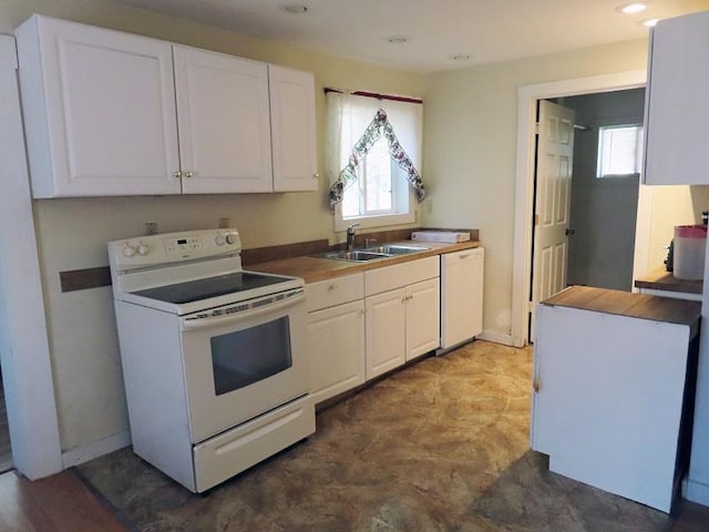 kitchen featuring sink, white appliances, and white cabinetry