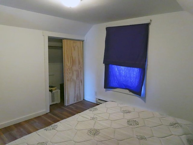 unfurnished bedroom featuring a closet, hardwood / wood-style floors, and a baseboard heating unit