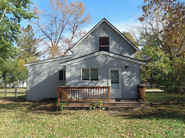 rear view of house with a wooden deck and a lawn