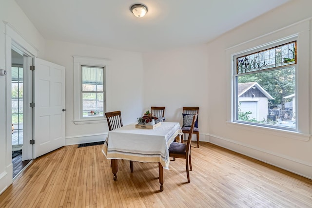 dining area with light hardwood / wood-style flooring and a healthy amount of sunlight