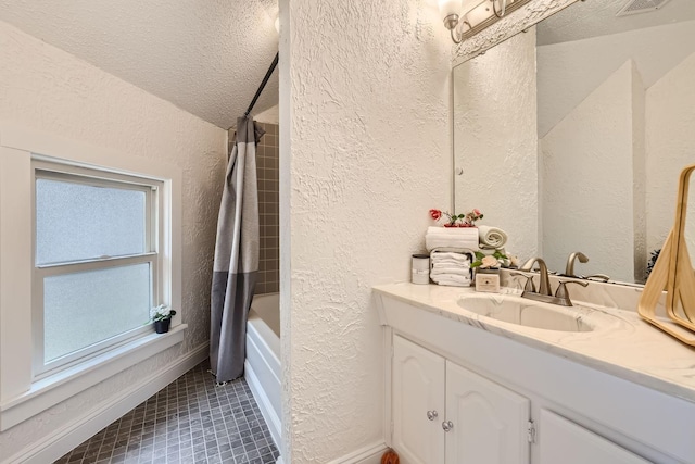 bathroom with shower / tub combo with curtain, tile patterned floors, vanity, and a textured ceiling