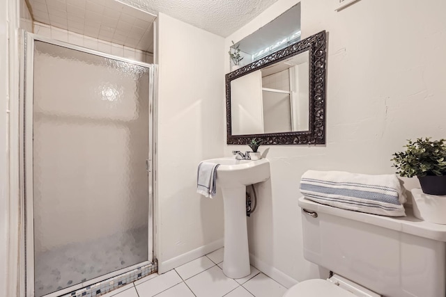 bathroom with toilet, tile patterned flooring, an enclosed shower, and a textured ceiling