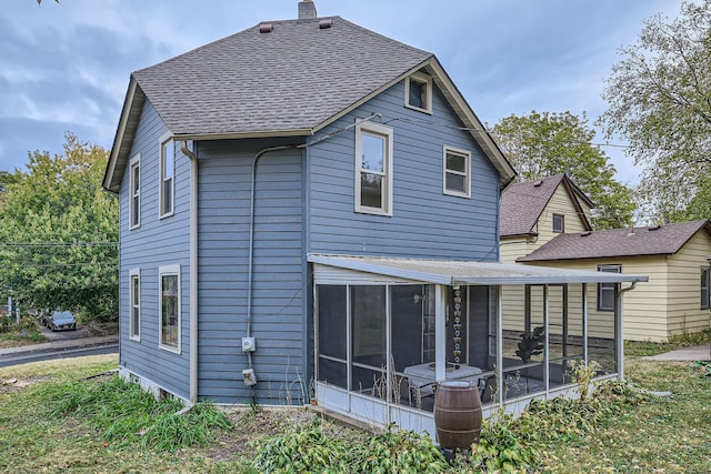 rear view of house featuring a sunroom