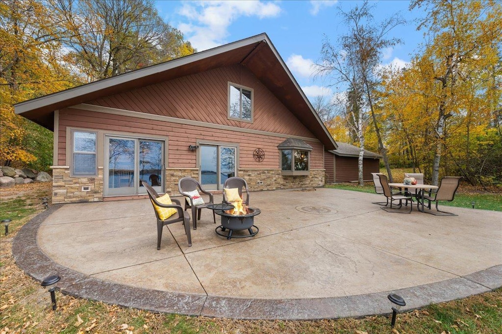 rear view of house featuring a patio and a fire pit