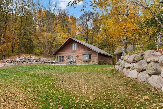 view of side of property featuring a lawn and a patio area