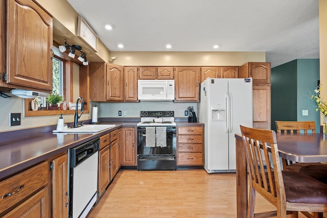 kitchen featuring light wood-type flooring, sink, and white appliances