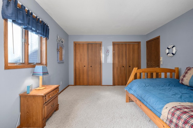 carpeted bedroom featuring multiple closets