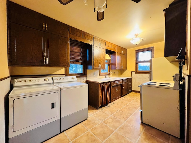 laundry room with light tile patterned flooring, sink, washing machine and dryer, and ceiling fan