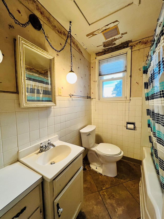 full bathroom featuring vanity, toilet, tile walls, and tile patterned flooring