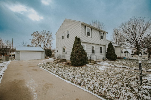 snow covered property with an outbuilding and a garage