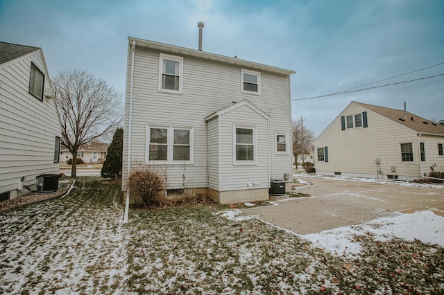 snow covered house featuring central air condition unit