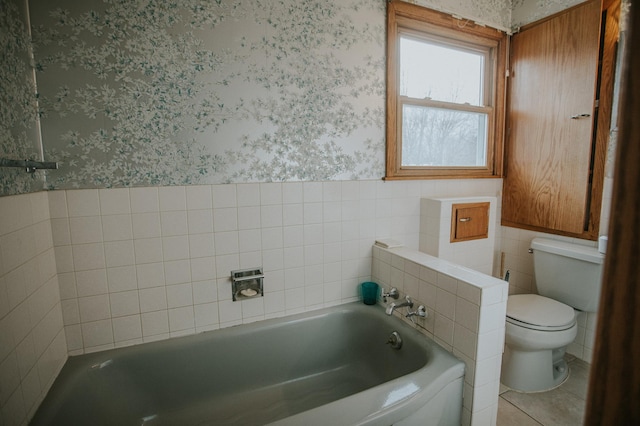 bathroom with a bath, toilet, tile walls, and tile patterned floors