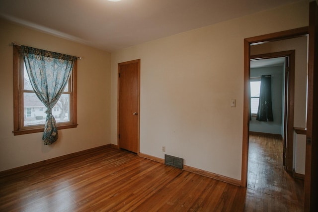 unfurnished room with hardwood / wood-style flooring