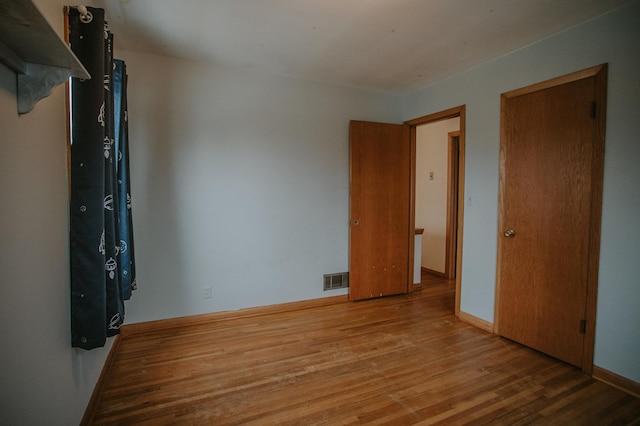 unfurnished bedroom featuring hardwood / wood-style flooring