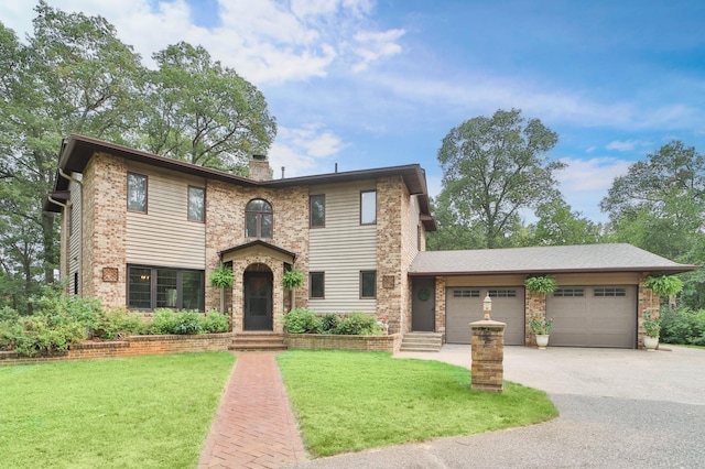 view of front of property featuring a front lawn, driveway, an attached garage, and a chimney