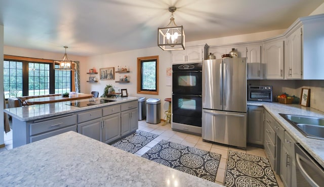 kitchen featuring black appliances, a notable chandelier, a wealth of natural light, and gray cabinets