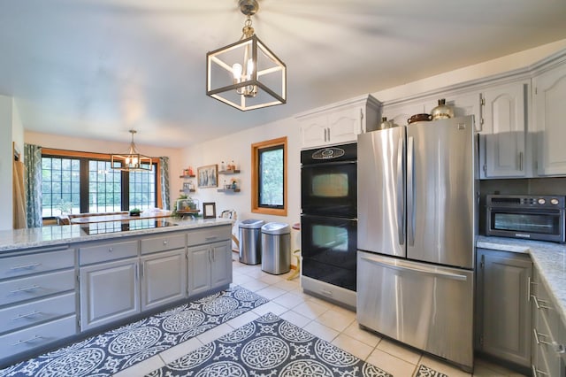 kitchen featuring light tile patterned floors, black appliances, an inviting chandelier, decorative light fixtures, and gray cabinets
