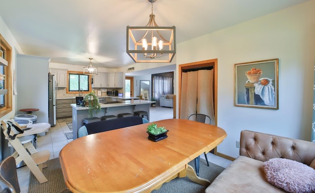 dining space with light tile patterned floors and a notable chandelier