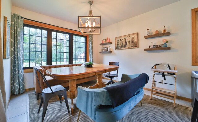 dining area featuring a chandelier and baseboards