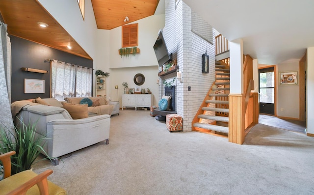 carpeted living area featuring stairs, a fireplace, and a towering ceiling