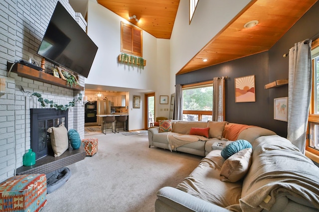 living area with wood ceiling, carpet, high vaulted ceiling, and a brick fireplace
