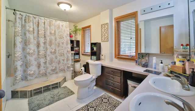 full bathroom featuring a shower with curtain, vanity, tile patterned floors, toilet, and a textured ceiling