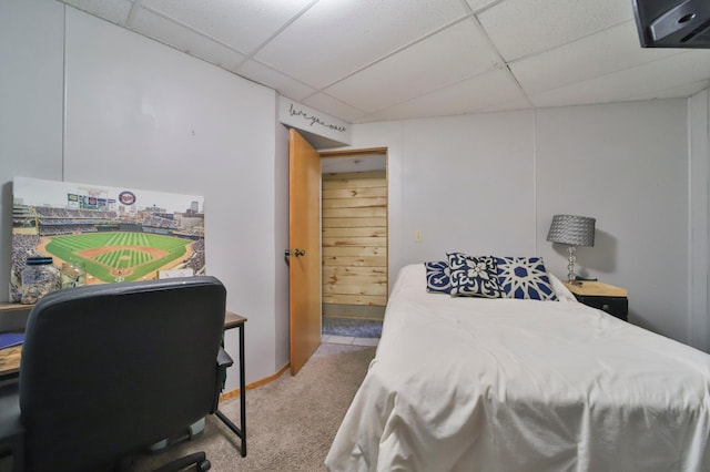 bedroom featuring a drop ceiling and carpet flooring